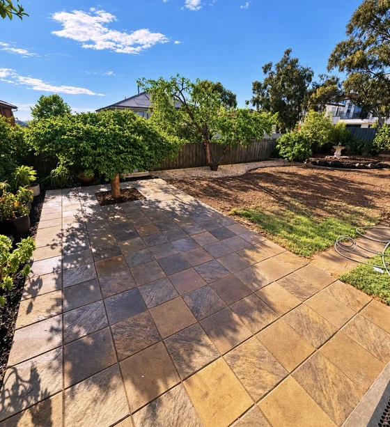 Warm stone paving alongside garden beds