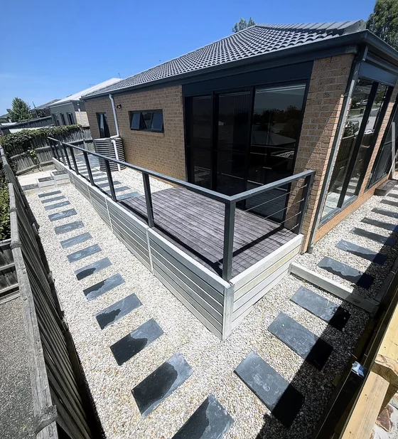 Deck with a metal balustrade and surrounding stepping stones